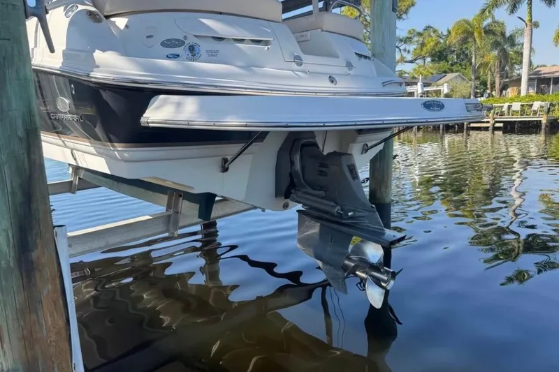 Slide: The Image of 2006 Chaparral 246 SSi boat on lift, partially submerged in calm water. - 4