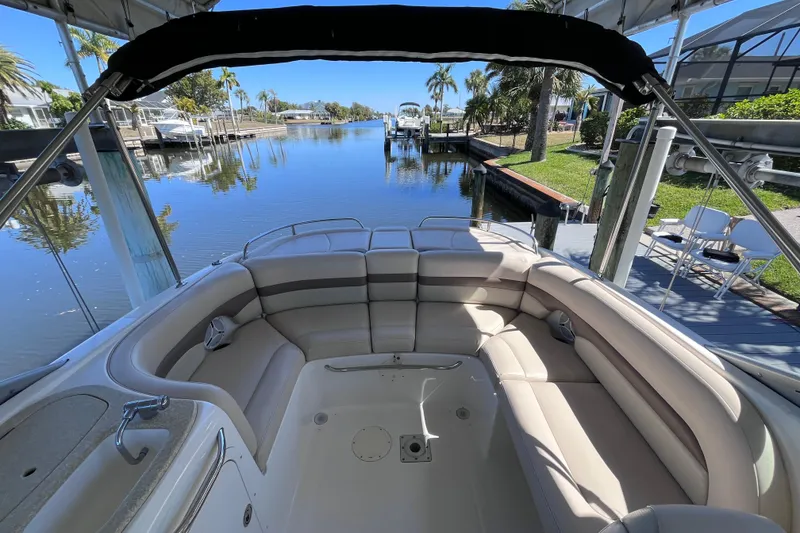 Slide: The Image of 2006 Chaparral 246 SSi boat interior with seating, docked by a scenic waterfront. - 41