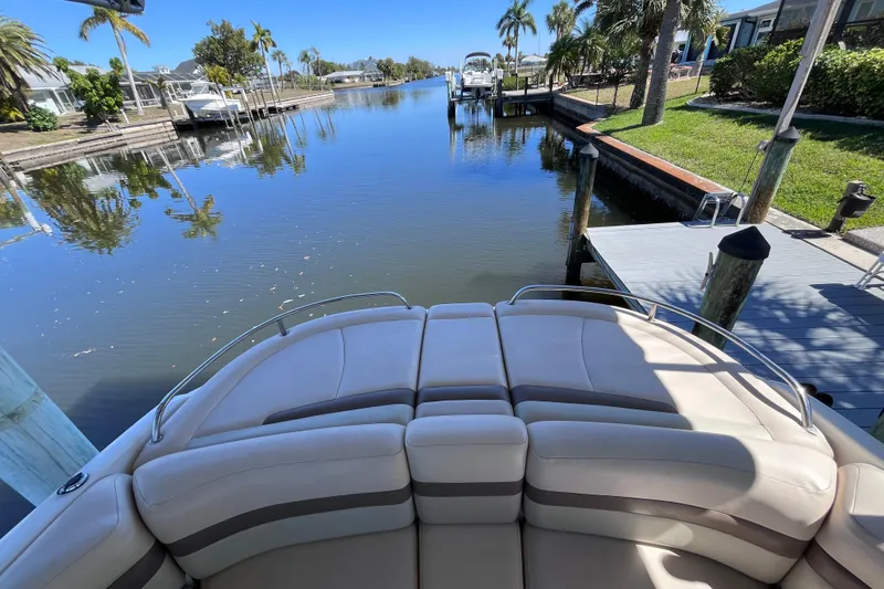 Slide: The Image of 2006 Chaparral 246 SSi boat docked on a serene canal with palm trees. - 42