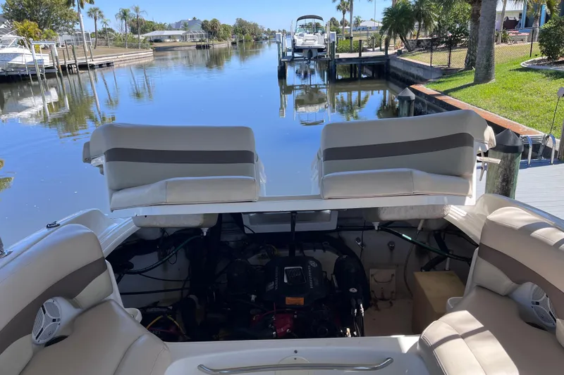 Slide: The Image of 2006 Chaparral 246 SSi boat with open engine compartment, docked by a serene canal. - 47