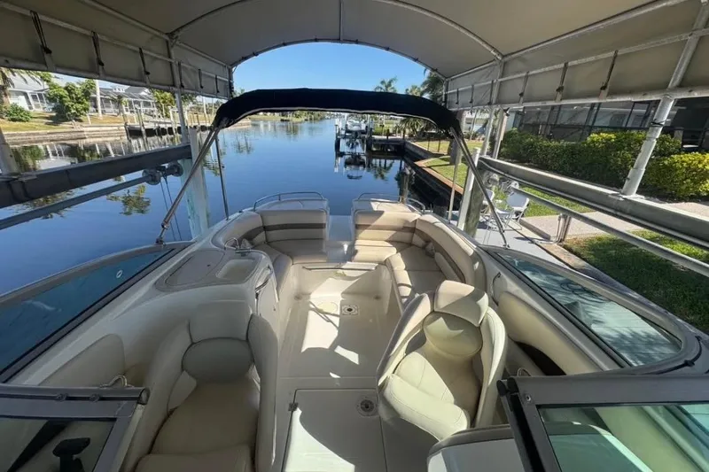 Slide: The Image of 2006 Chaparral 246 SSi boat interior under canopy, docked by a serene canal. - 7