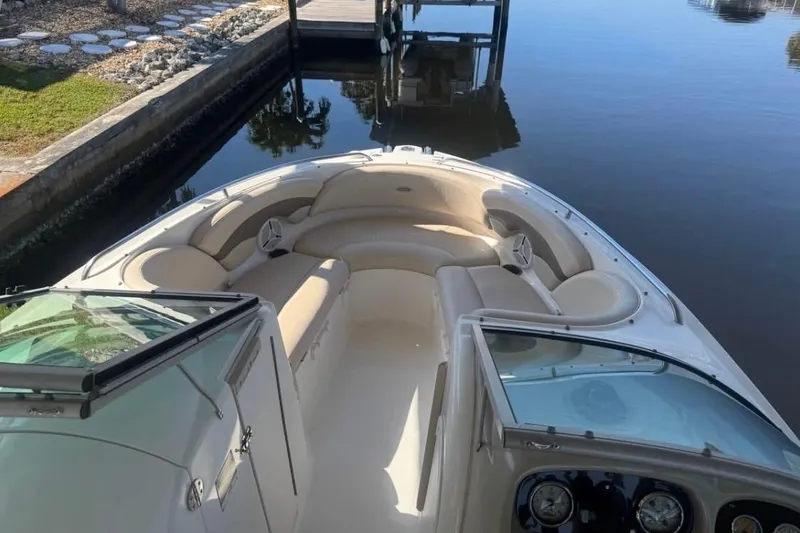 Slide: The Image of 2006 Chaparral 246 SSi boat with spacious seating, docked by calm waters. - 8