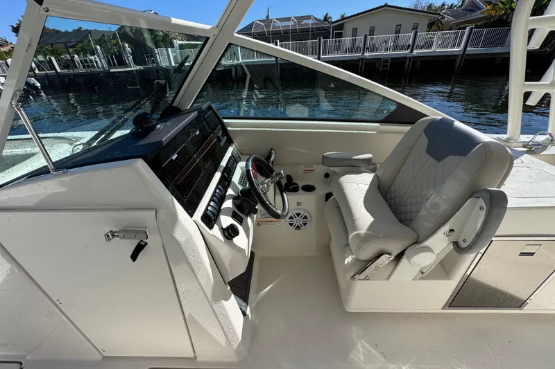 Slide: The Image of 2025 Sailfish 276 DC boat interior with steering wheel and comfortable seating. - 11