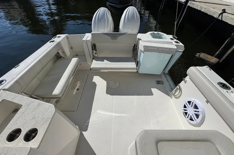 Slide: The Image of 2025 Sailfish 276 DC boat interior with seating and storage, docked by the water. - 23