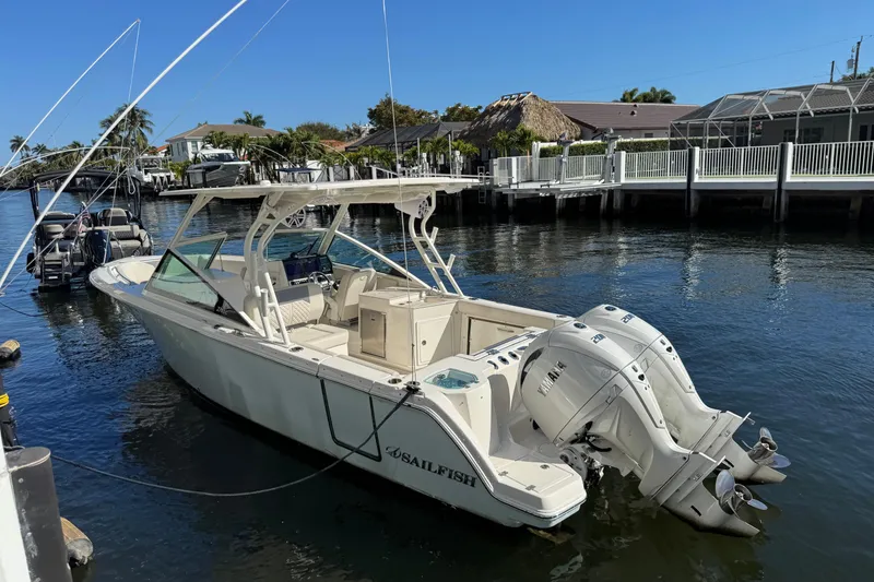 Slide: The Image of 2025 Sailfish 276 DC boat docked in a sunny marina setting. - 3