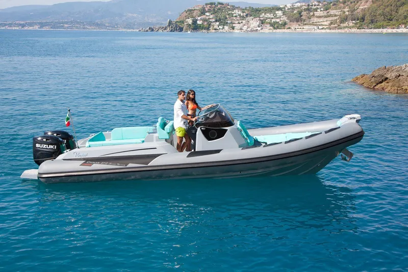 Slide: The Image of 2026 Ranieri CAYMAN 27.0 SPORT TOURING boat on clear blue water, with two people onboard. - 7