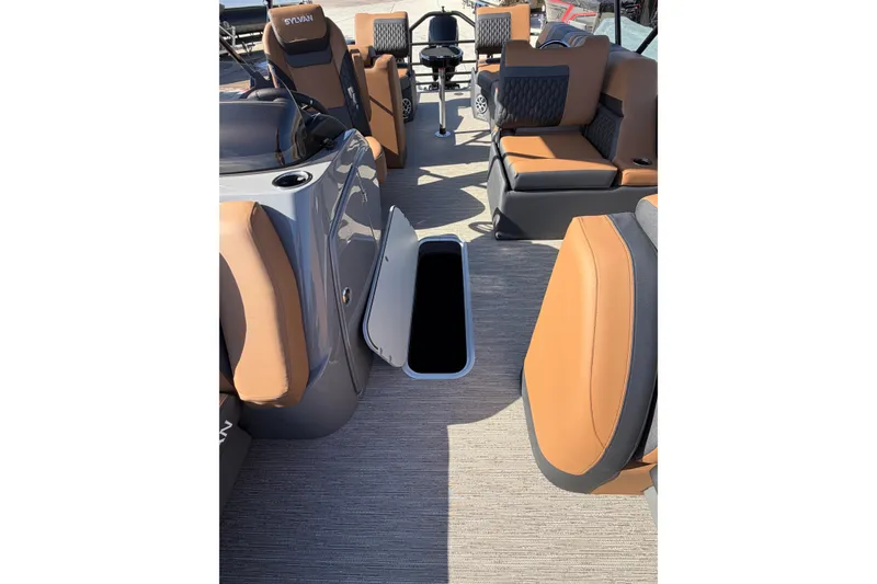 Slide: The Image of 2025 Sylvan L-3 SLZ boat interior with tan seating and open storage compartment. - 10