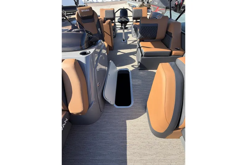 Slide: The Image of 2025 Sylvan L-3 SLZ boat interior with tan and gray seating, open storage compartment. - 9