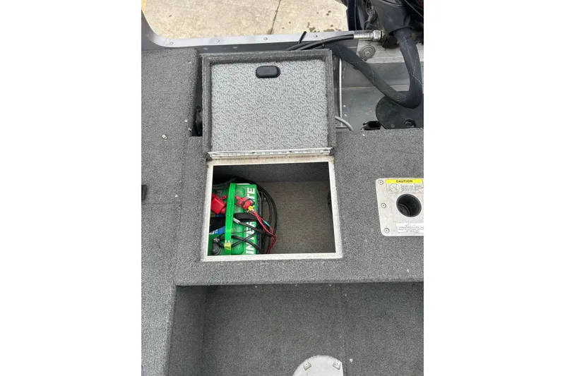 Slide: The Image of Open battery compartment in 2015 Lund 1775 Impact boat, showing marine battery and wiring. - 14