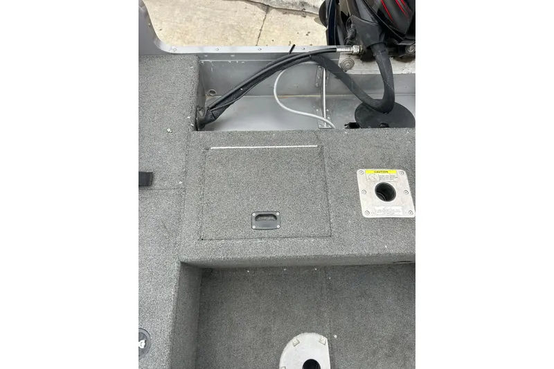 Slide: The Image of 2015 Lund 1775 Impact boat interior with storage compartment and caution label. - 17