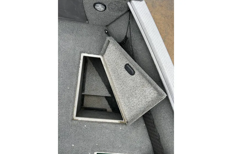 Slide: The Image of 2015 Lund 1775 Impact boat storage compartment with open lid, showing interior space. - 25