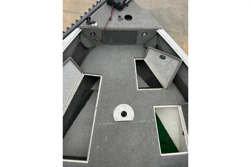 Slide: The Image of 2015 Lund 1775 Impact boat interior with open storage compartments and carpeted flooring. - 26