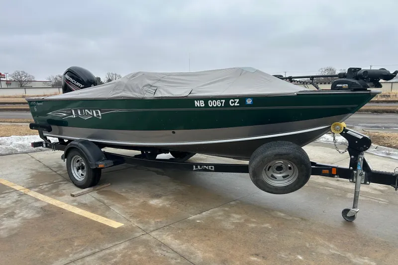 Slide: The Image of 2015 Lund 1775 Impact boat on trailer, covered, with Mercury engine, parked on concrete. - 8