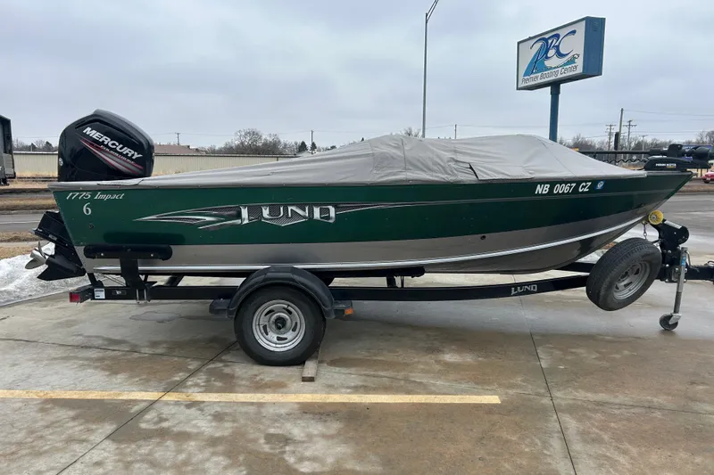 Slide: The Image of 2015 Lund 1775 Impact boat on trailer with cover, featuring Mercury engine. - 9
