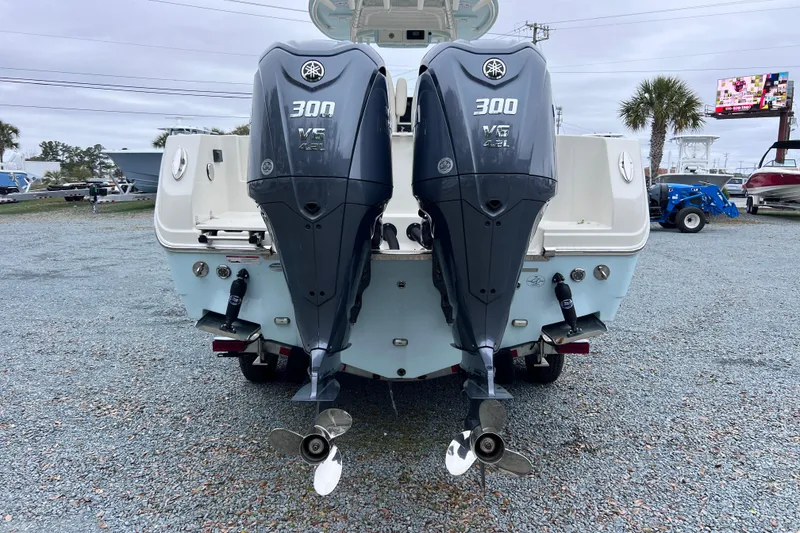 Slide: The Image of 2024 Sailfish 290 CC boat interior with white cushioned seating and cup holders. - 13