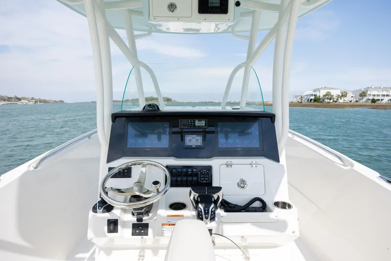 Slide: The Image of 2024 Sailfish 290 CC boat helm with modern controls and ocean view. - 18