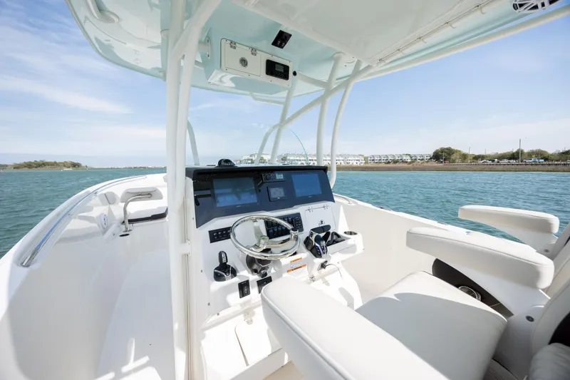 Slide: The Image of 2024 Sailfish 290 CC boat cockpit with modern controls on open water. - 20