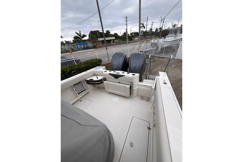Slide: The Image of 2024 Sailfish 290 CC boat deck with dual engines, outdoor setting. - 4