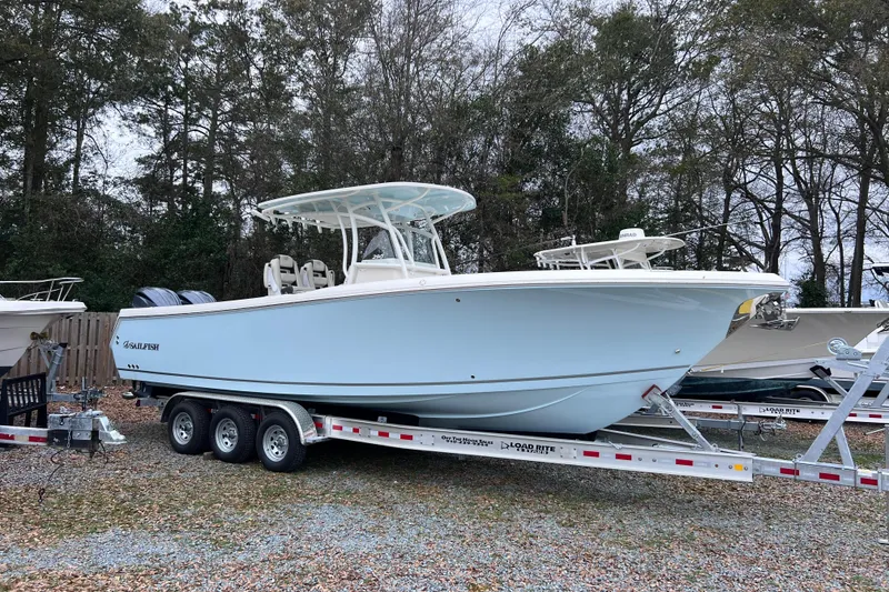 Slide: The Image of 2024 Sailfish 290 CC boat on trailer, side view, parked outdoors. - 5