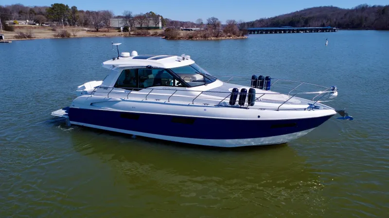 Slide: The Image of 2012 Cruisers Yachts 48 Cantius on a serene lake, showcasing sleek design and luxury. - 2