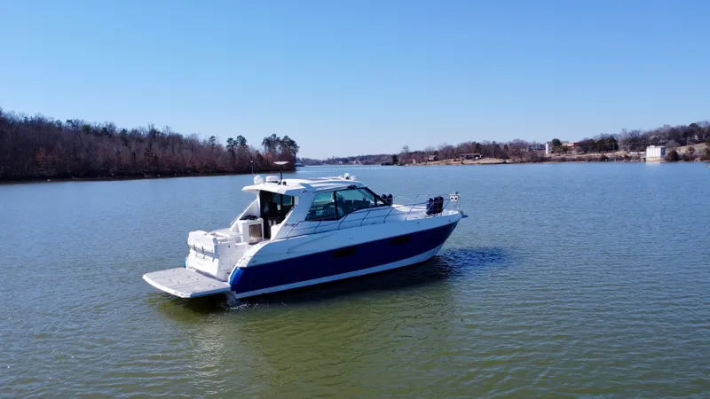 Slide: The Image of 2012 Cruisers Yachts 48 Cantius on a serene lake under clear blue skies. - 23