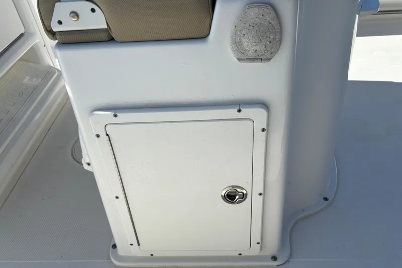 Slide: The Image of 2016 Sea Hunt Gamefish 27 boat console with storage compartment and cushioned seat. - 14