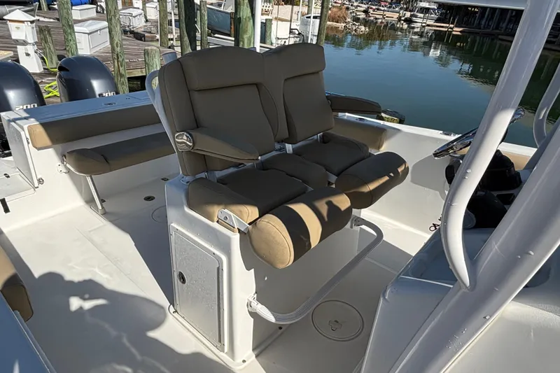 Slide: The Image of 2016 Sea Hunt Gamefish 27 boat interior with cushioned seating and dual outboard motors. - 16