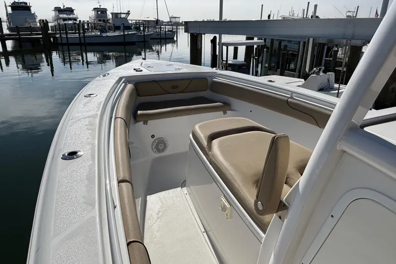 Slide: The Image of 2016 Sea Hunt Gamefish 27 boat interior with tan seating at marina. - 19
