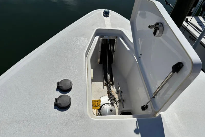 Slide: The Image of 2016 Sea Hunt Gamefish 27 anchor locker with open hatch, showing anchor mechanism. - 24