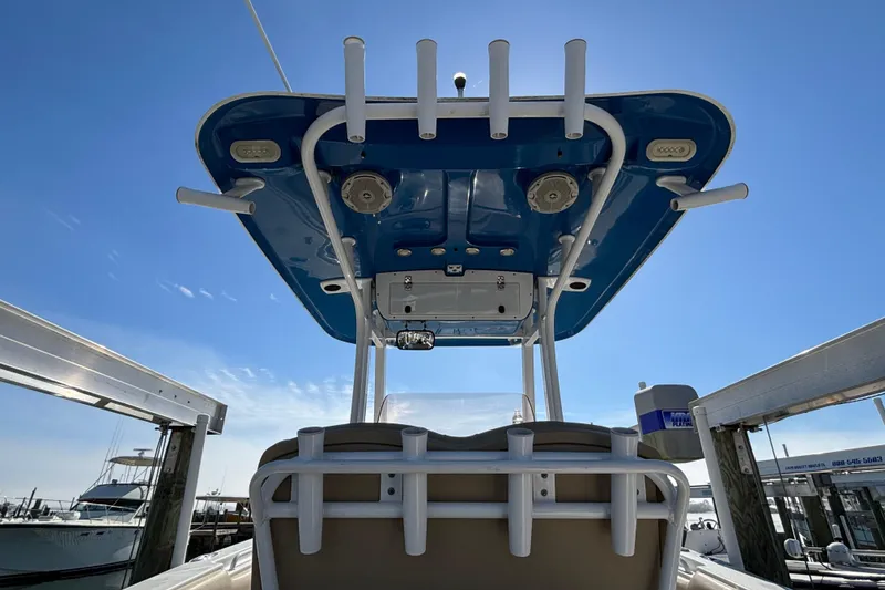 Slide: The Image of 2016 Sea Hunt Gamefish 27 boat with T-top and rod holders under clear blue sky. - 27