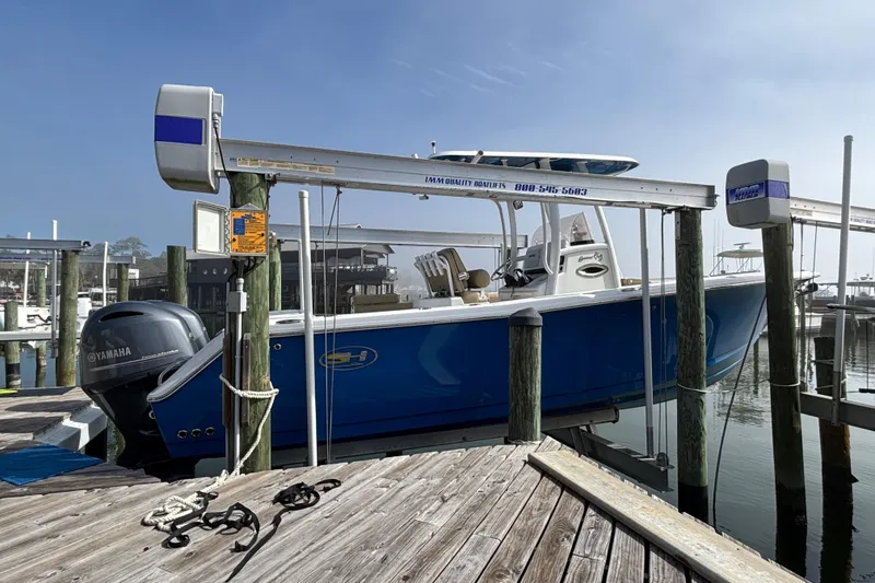 Slide: The Image of 2016 Sea Hunt Gamefish 27 boat docked with Yamaha engine, blue hull. - 4
