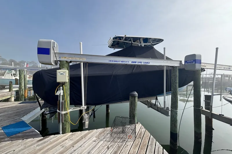 Slide: The Image of 2016 Sea Hunt Gamefish 27 boat covered and docked on a lift at a marina. - 5