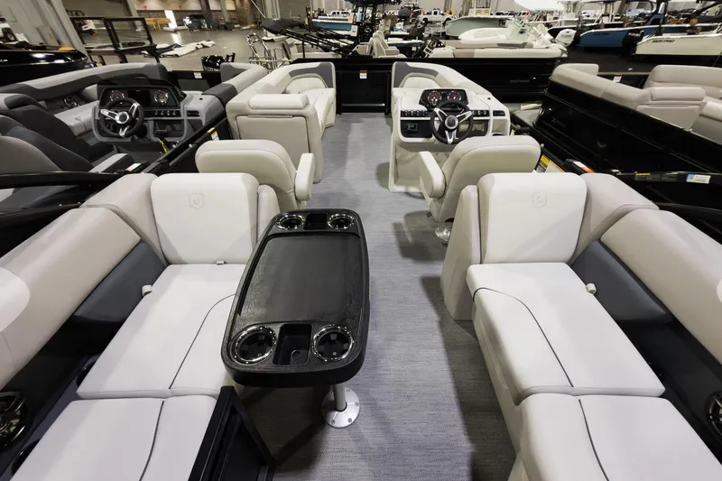 Slide: The Image of 2026 Godfrey Sweetwater 22' Split Bench Tritoon interior with plush seating and modern dashboard. - 11