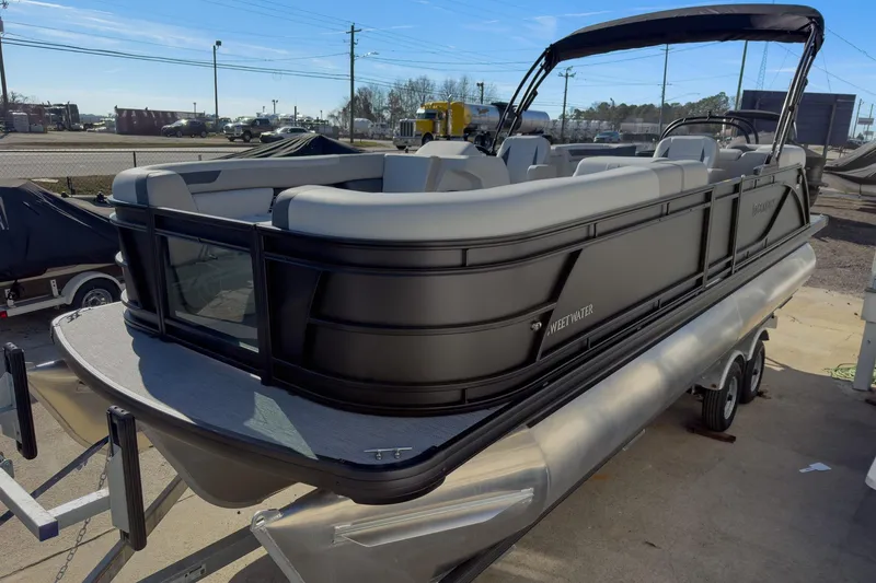 Slide: The Image of 2026 Godfrey Sweetwater 22' Split Bench Tritoon, sleek design, parked on trailer. - 17