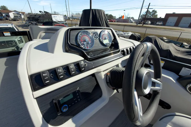 Slide: The Image of 2026 Godfrey Sweetwater 22' Tritoon dashboard with steering wheel and control panel. - 38