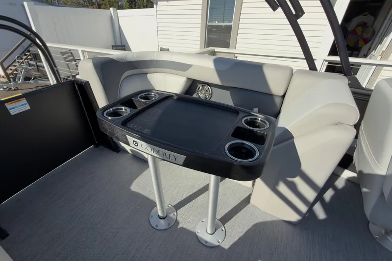 Slide: The Image of 2026 Godfrey Sweetwater 22' Tritoon interior with split bench and table. - 48