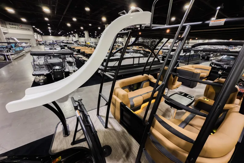 Slide: The Image of 2026 Godfrey Monaco 255 Sun Deck boat with slide, luxurious seating, and modern design in showroom. - 28