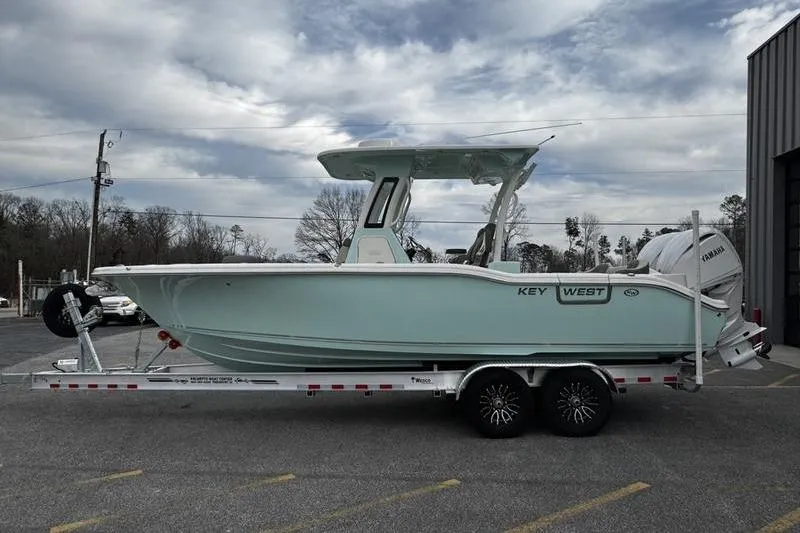 The Image of 2026 Key West 263 FS boat on trailer, parked outdoors under cloudy sky. - 0