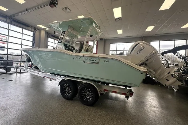 Slide: The Image of 2026 Key West 263 FS boat on trailer, parked outside a building under cloudy sky. - 10