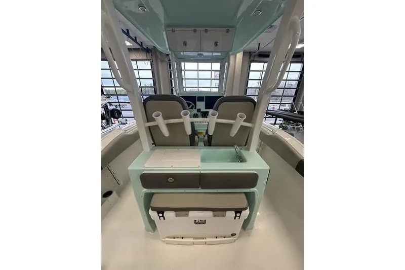 Slide: The Image of 2026 Key West 263 FS boat with beige cushioned seating, on calm water. - 32