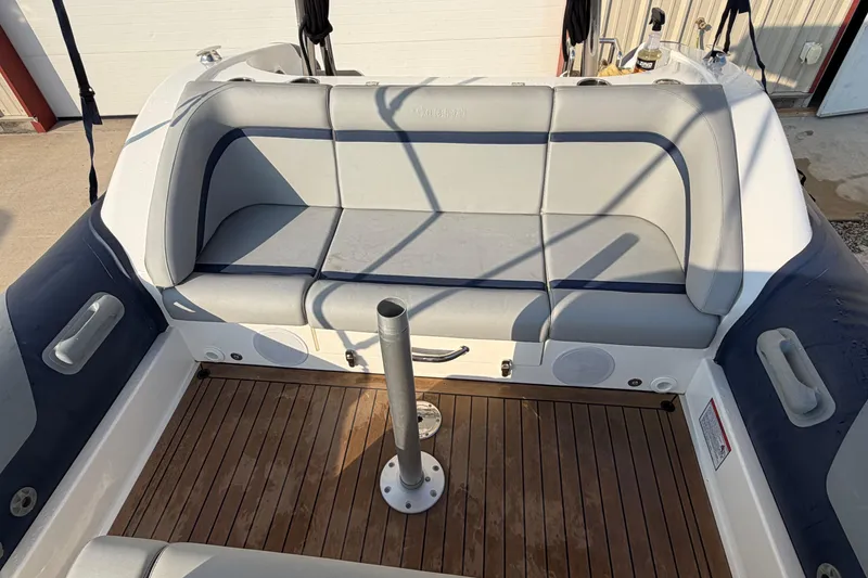 Slide: The Image of 2023 Cobra Ribs Nautique 7.0m boat interior with cushioned seating and wooden deck. - 11