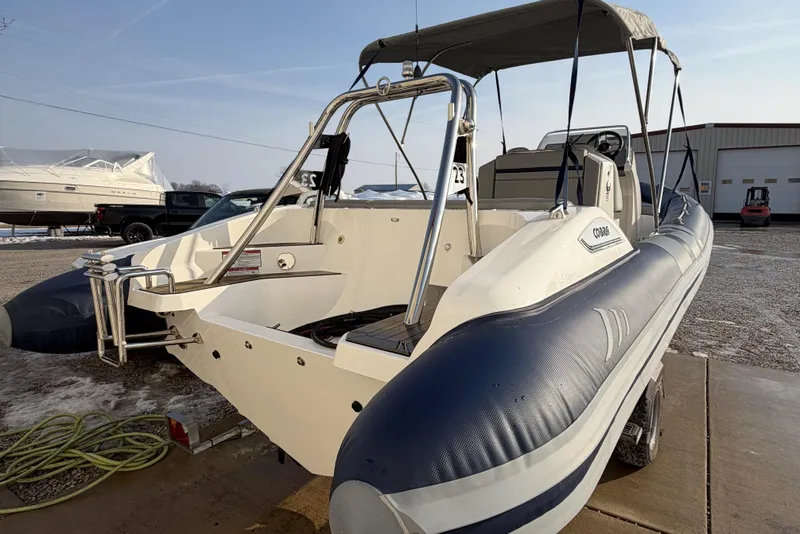 Slide: The Image of 2023 Cobra Ribs Nautique 7.0m boat with canopy, parked outdoors on a sunny day. - 5