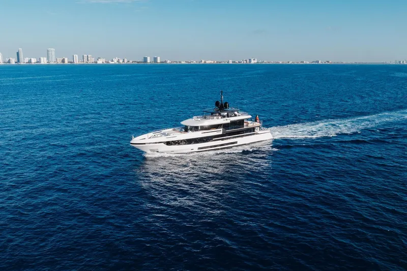 Slide: The Image of 2024 Mangusta Oceano 44 yacht cruising on open sea near city skyline. - 11