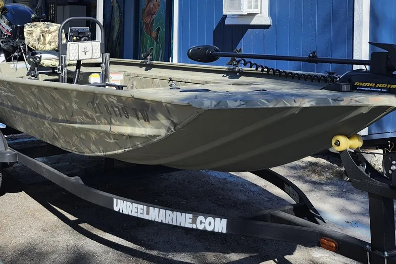 The Image of 2025 Tracker Grizzly 1654 MVX Sportsman boat on trailer, parked outdoors. - 1