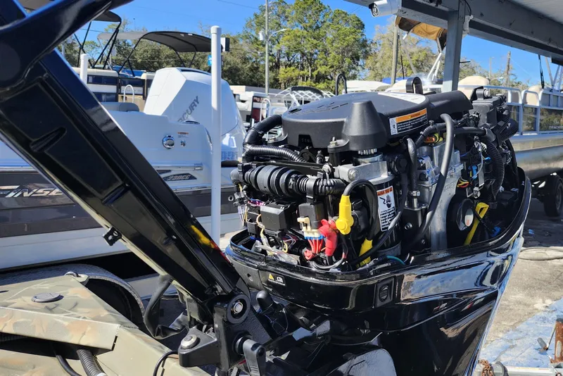 Slide: The Image of 2025 Tracker Grizzly 1654 MVX Sportsman boat engine, detailed view in a marina setting. - 10