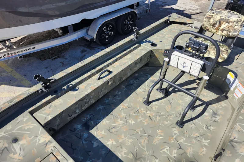 Slide: The Image of 2025 Tracker Grizzly 1654 MVX Sportsman boat with camouflage design and seating. - 17