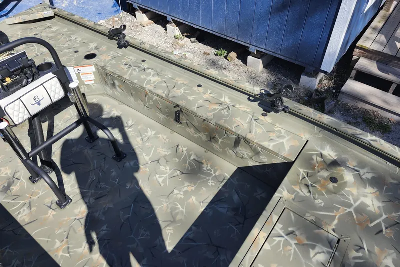 Slide: The Image of 2025 Tracker Grizzly 1654 MVX Sportsman boat interior with camouflage design and fishing equipment. - 18