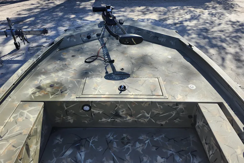 Slide: The Image of 2025 Tracker Grizzly 1654 MVX Sportsman boat interior with camouflage design and mounted equipment. - 19