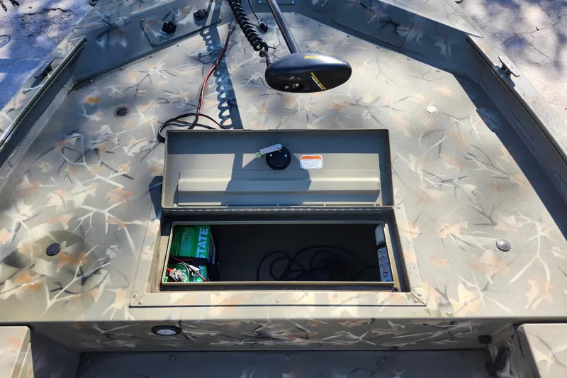 Slide: The Image of 2025 Tracker Grizzly 1654 MVX Sportsman boat with open storage compartment and camouflage design. - 20