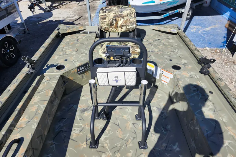 Slide: The Image of 2025 Tracker Grizzly 1654 MVX Sportsman boat interior with camouflage seating and control panel. - 21